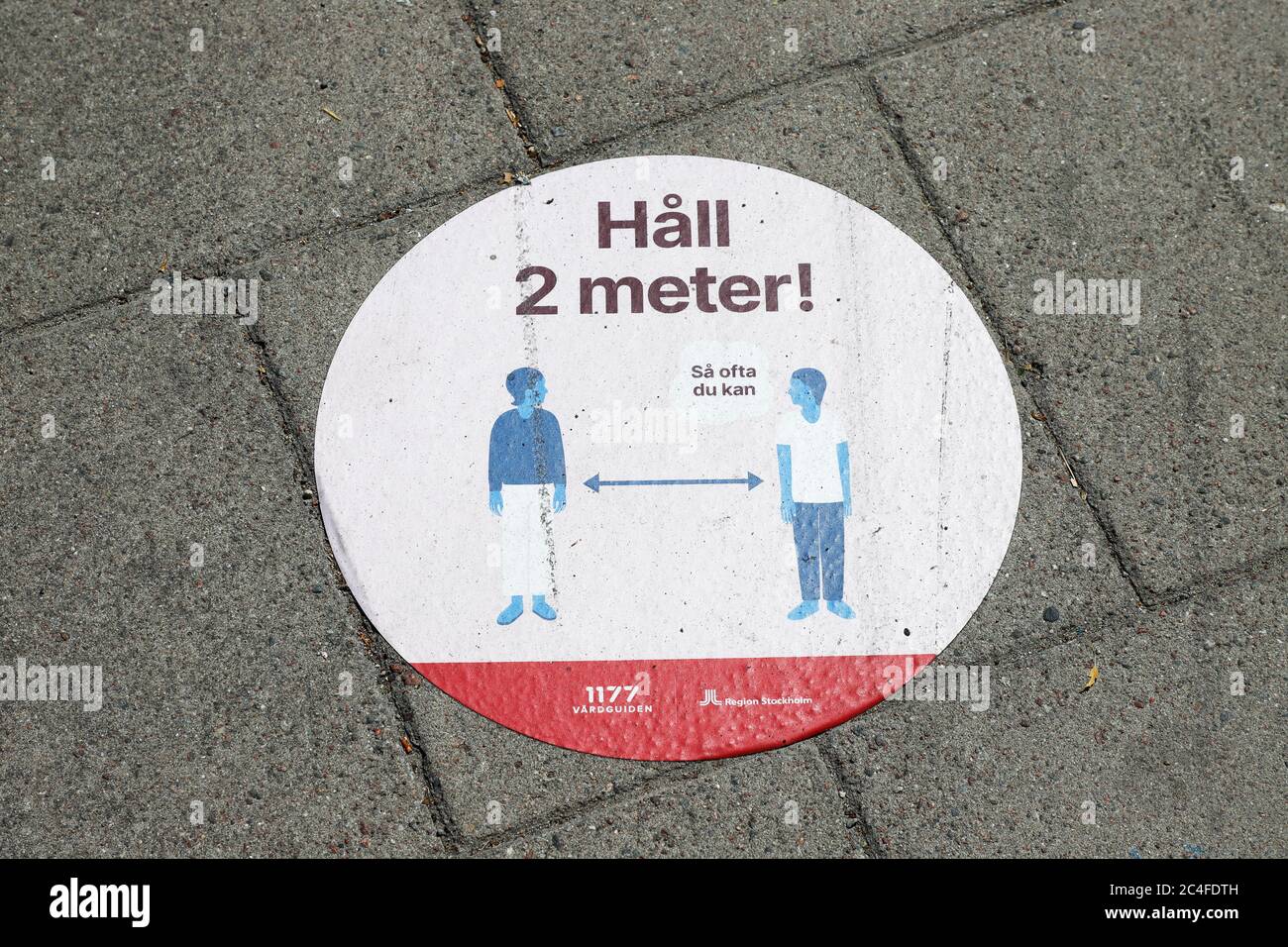 Nynashamn, Schweden - 26. Juni 2020: Aufkleber auf dem Bürgersteig erinnert die Bürger, zwei Meter Abstand voneinander zu halten, um die Ausbreitung der Covi zu reduzieren Stockfoto