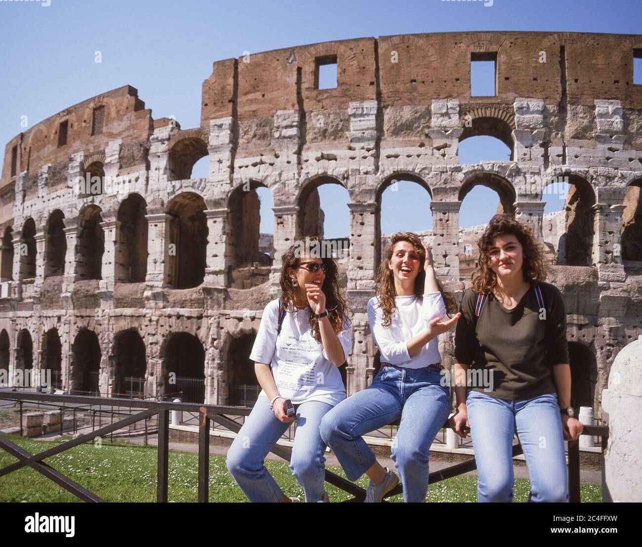 Junge Frauen, die am späten Nachmittag vor dem Kolosseum (Colosseo) sitzen, IV. Templum Pacis, Rom (Roma), Region Latium, Italien Stockfoto
