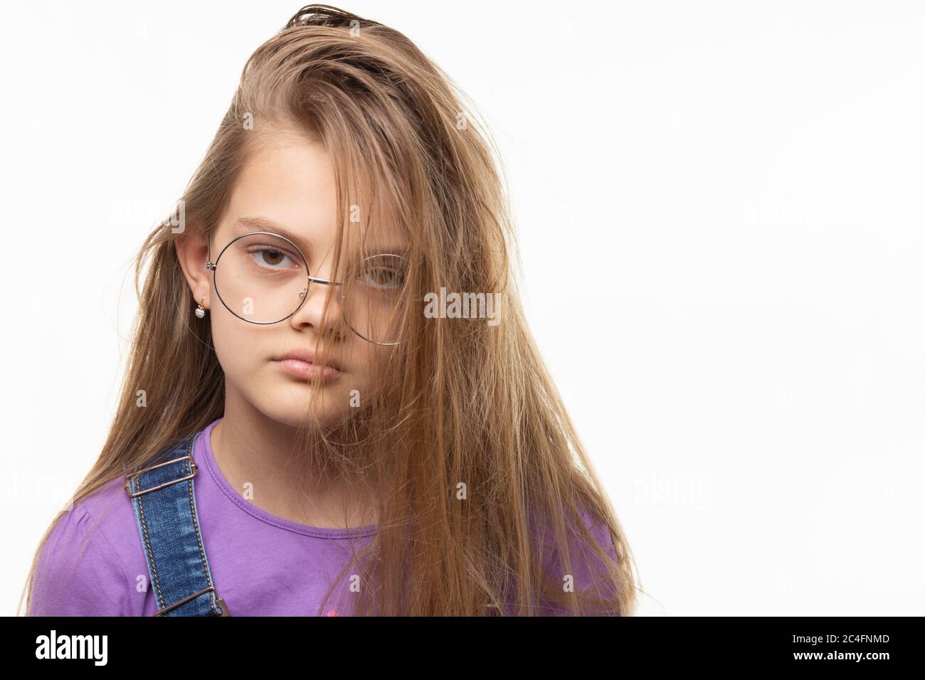 Porträt eines elfjährigen Mädchens auf weißem Hintergrund mit originaler Frisur Stockfoto