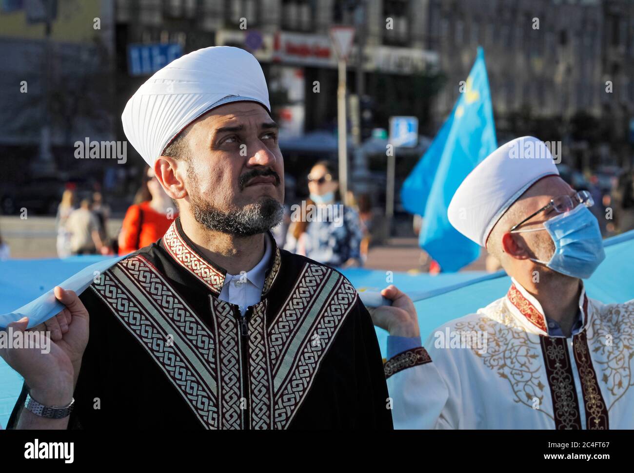 Krimtataren Menschen halten während der Feier Nationalflaggen.Krimtataren feiern jährlich am 26. Juni den Krimtatarischen Flaggentag. Die Flagge der Krimtataren ist ein blaues Tuch mit einem gelben Emblem - Tamga - in der oberen linken Ecke. Die Flagge wurde erstmals 1917 vom Kurultai (Nationalkongress) der Krimtataren nach der Februarrevolution in Russland angenommen. Am 30. Juni 1991 hat der neu einberufene Kurultay diese Flagge als nationale Flagge wieder aufgenommen, so Wikipedia. Stockfoto