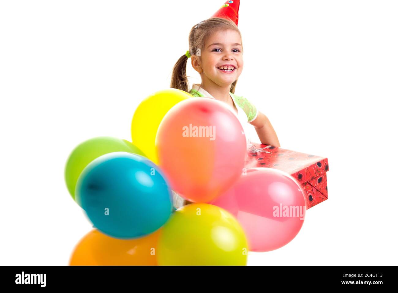 Kleines fröhliches Mädchen feiert Geburtstag mit bunten Ballonen Stockfoto
