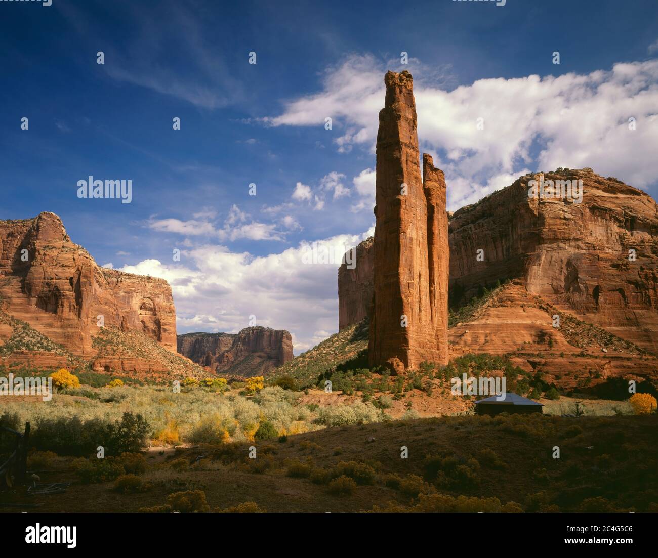 Canyon de Chelly National Monument AZ / OCT Blick auf Spider Rock und Wolken gefüllt Himmel hinter hogan auf dem Boden des Canyon de Chelly. Stockfoto