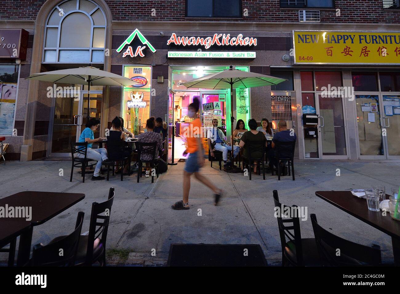 New York City, USA. Juni 2020. Gäste speisen im Freien an Tischen auf dem Bürgersteig vor dem indonesischen Restaurant Awang Kitchen am Queens Boulevard im Elmhurst-Viertel von Queens, NY, 26. Juni 2020. In Phase II können Restaurants Kunden an Tischen auf dem Bürgersteig bedienen und vom Bürgersteig aus 8 Fuß in die Straße fahren, um die weitere Ausbreitung der COVID-19-Pandemie zu verhindern. (Anthony Behar/Sipa USA) Quelle: SIPA USA/Alamy Live News Stockfoto