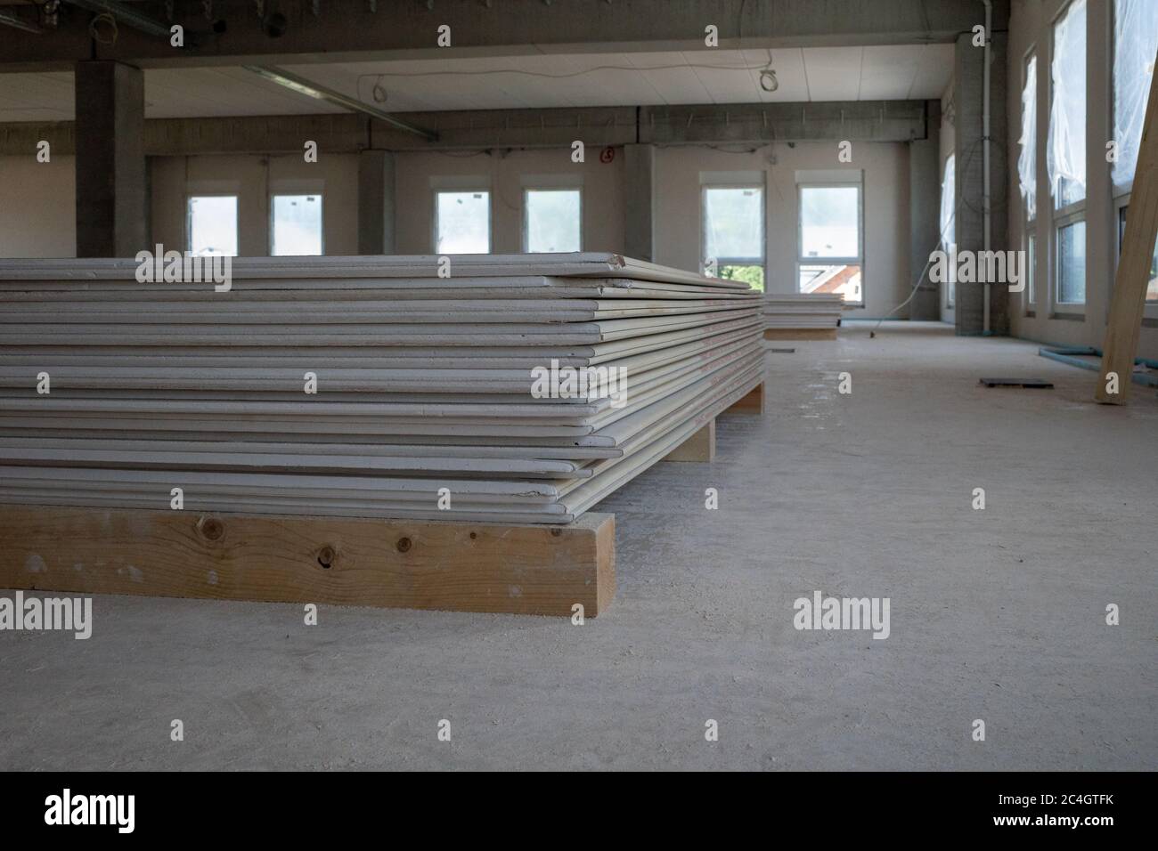 Trockenbauplatten liegen auf dem Boden eines Fabrikgebäudes auf einer Baustelle Stockfoto