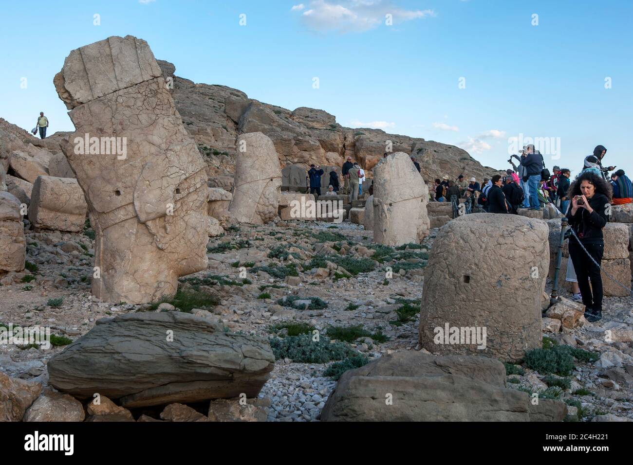 Touristen auf der westlichen Plattform am Mount Nemrut in der Türkei. Steinstatuen, die hier zu finden sind, sind ein persischer adlergott, Herkules, Antiochus und Zeus. Stockfoto