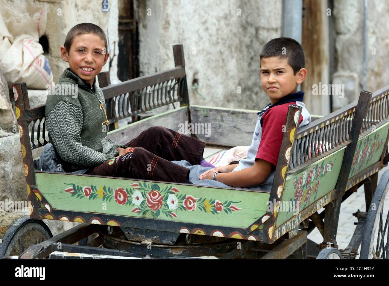Türkische Jungen sitzen in einem Holzwagen auf einer Straße in der Stadt Goreme in der Region Kappadokien in der Türkei. Stockfoto
