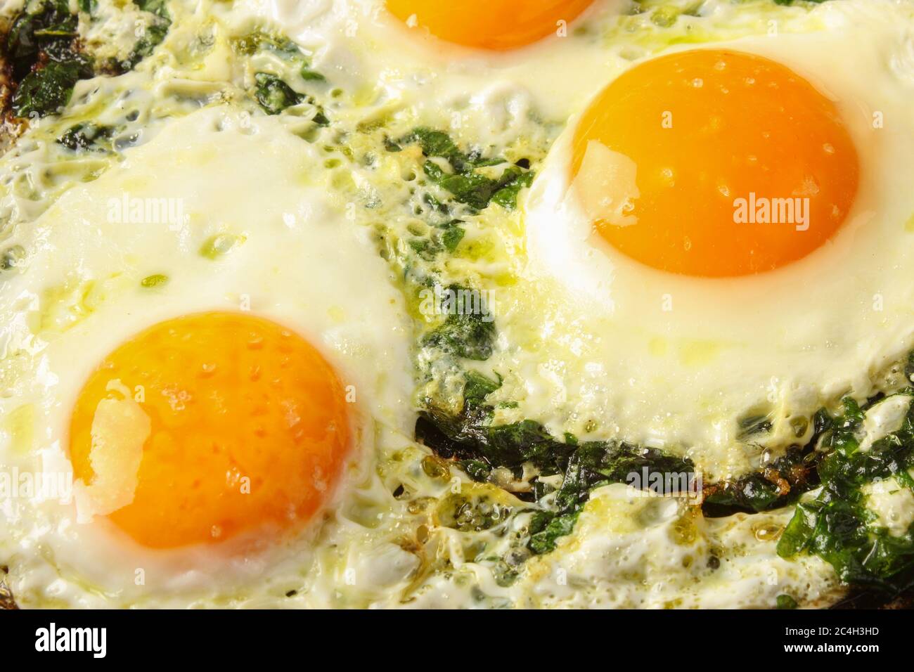 Spiegeleier mit Spinat in einer Pfanne Stockfoto