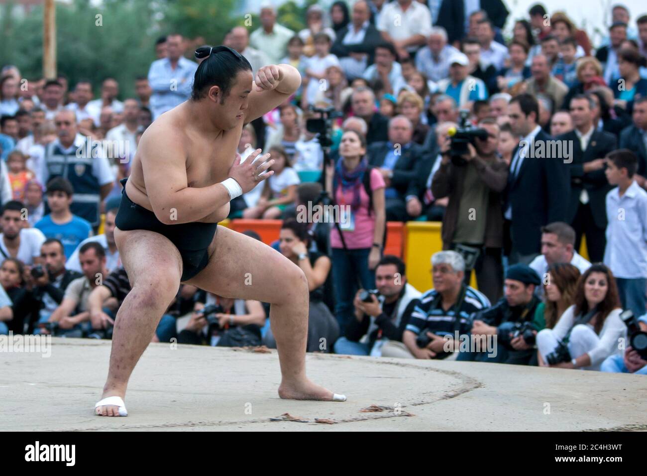 Ein japanischer Sumo-Wrestler bereitet sich während einer Ausstellungsschlacht in Edirne in der Türkei auf die Schlacht vor. Eine große Menge türkischer Menschen beobachten. Stockfoto