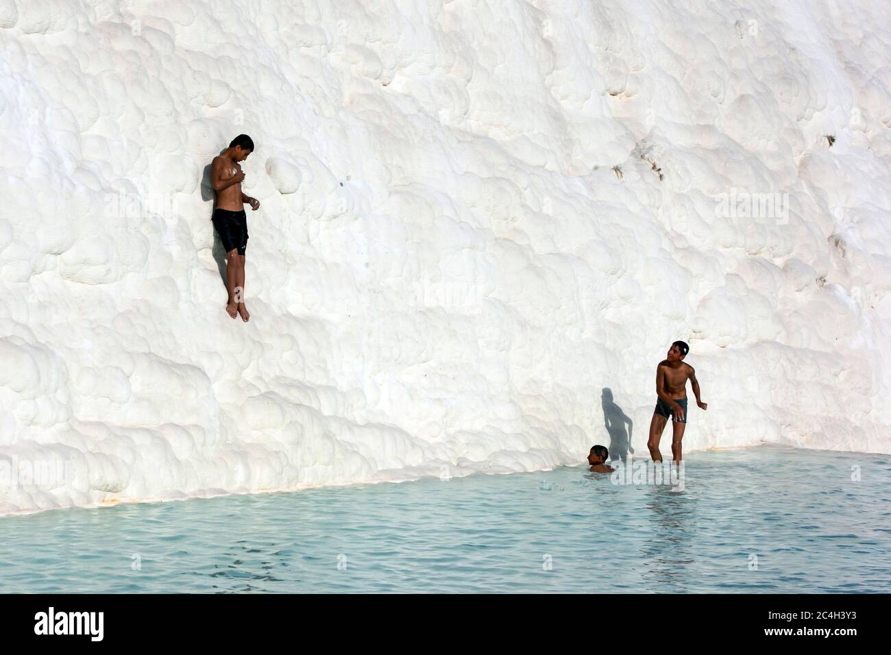 Türkische Jungen spielen am späten Nachmittag auf den Travertinen (Cotton Castle) in Pamukkale in der Türkei. Stockfoto