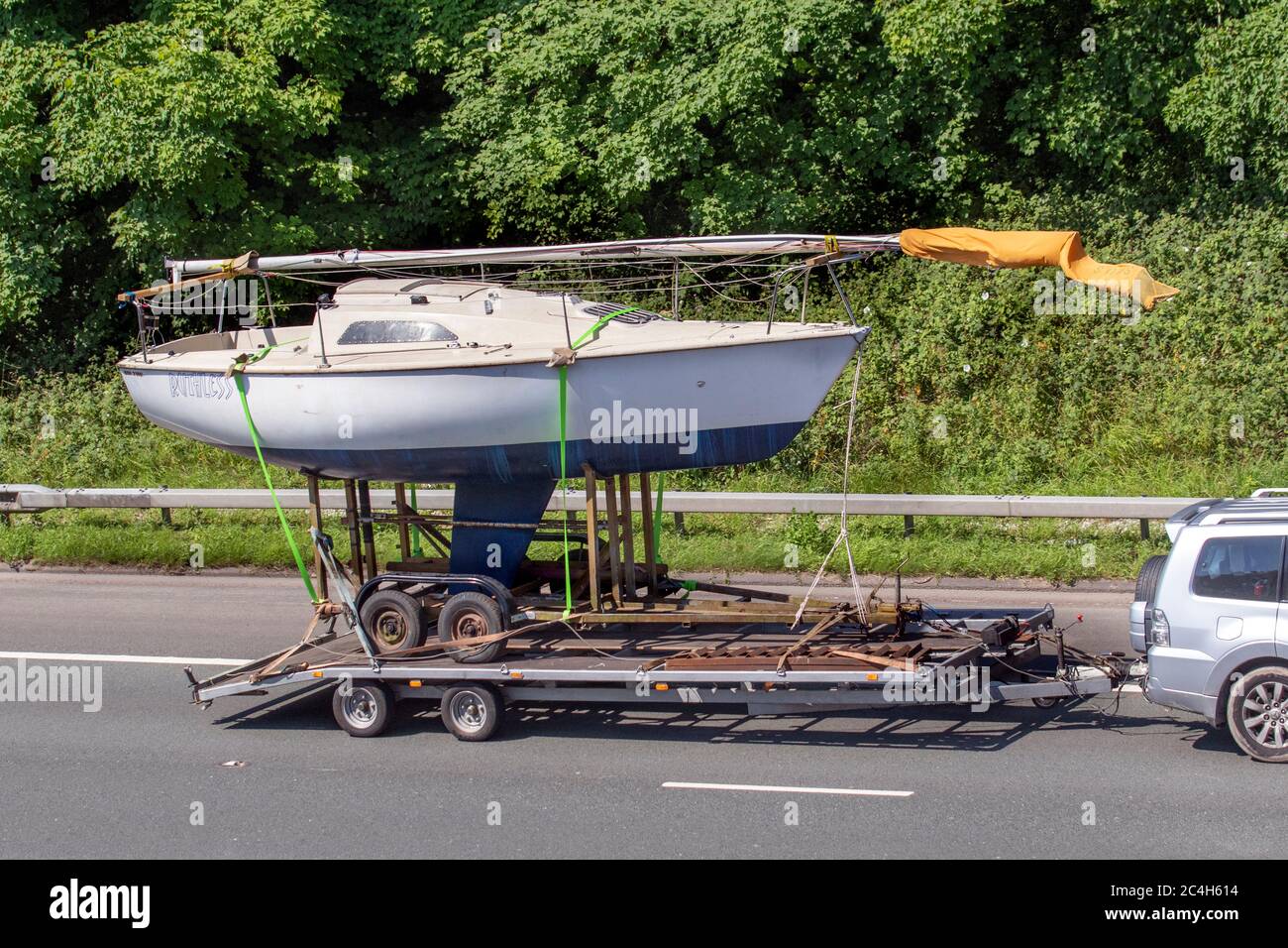 Große, übergroße Segelyacht auf dem Boot & Straßenanhänger, die auf der M6 Motorway, Großbritannien, geschleppt wird Stockfoto