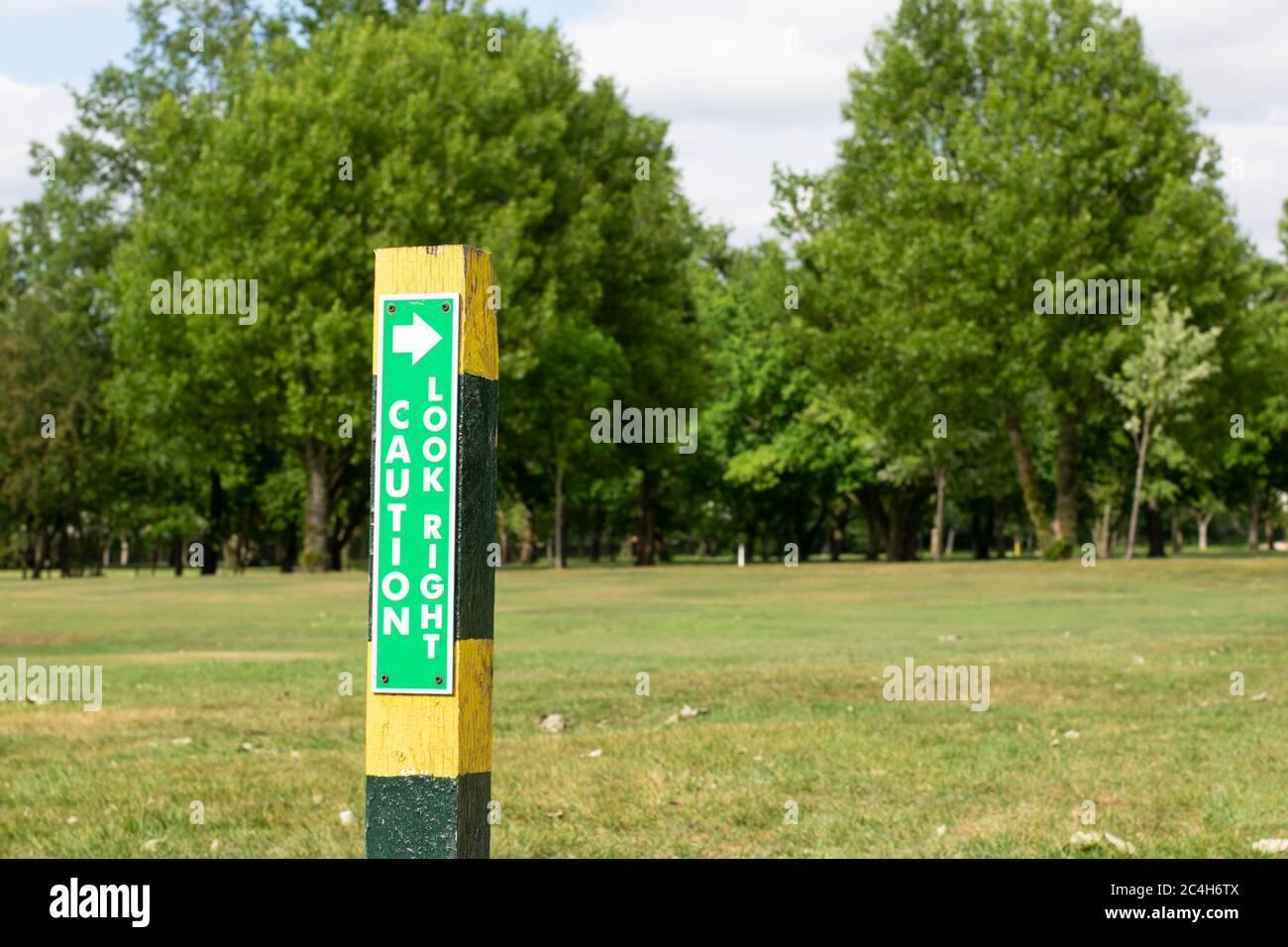Post with Text Vorsicht nach rechts schauen.Melden Sie sich auf öffentlichen Fußweg durch Heaton Moor Golf Club, Stockport UK. Bäume im Hintergrund. Stockfoto