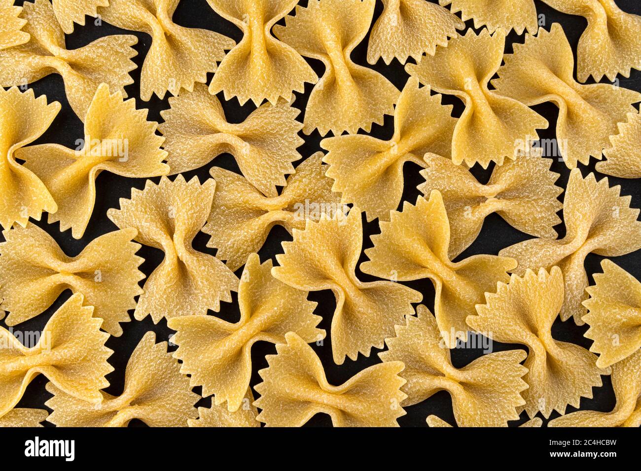 Farfalle Pasta Muster auf schwarzem Hintergrund, Draufsicht, flache Lay Textur Stockfoto