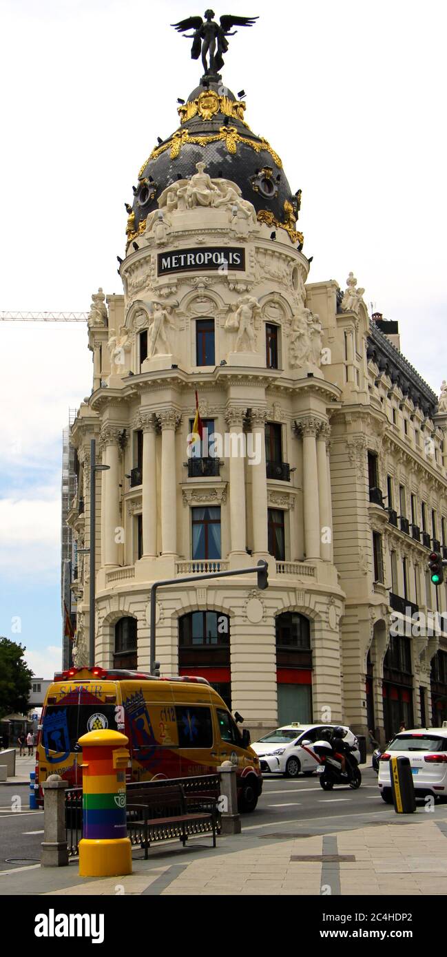 Metropolis Gebäude Madrid Spanien mit einem Krankenwagen vorbei in der Vordergrund und ein Briefkasten mit Regenbogenfarben für dekoriert Gay Pride Week Stockfoto