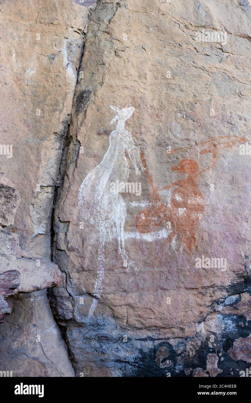 Burrungkuy, Australien - 12. März 2020: Einheimische Rockkunst der Aborigines, die einen Jäger und ein Känguru zeigt Stockfoto