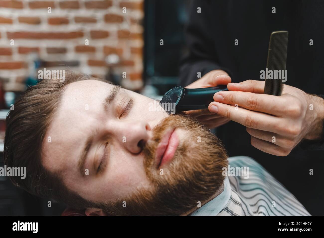 Master Friseur schneidet Client-Bart mit elektrischen Trimmer Stockfoto