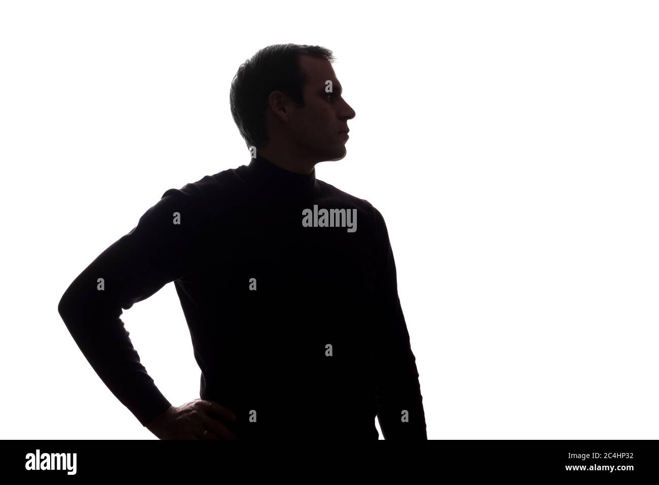 Porträt eines jungen Mannes, Hand auf Hüften, Seitenansicht - Silhouette Stockfoto
