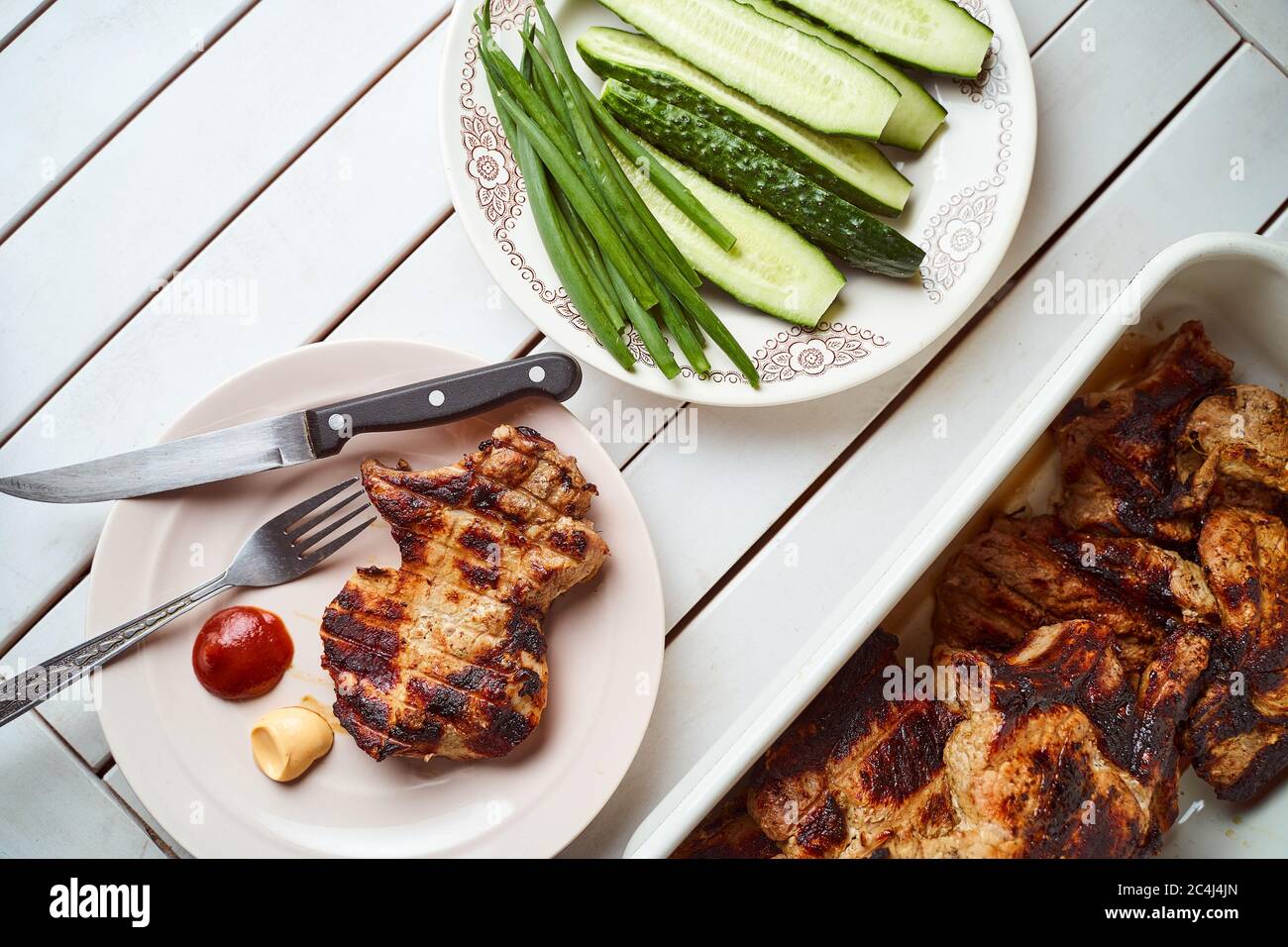 Fertig Schweinesteak in einem weißen Teller mit grünen Zwiebeln auf einem weißen Teller. Mit Kopierbereich. Stockfoto