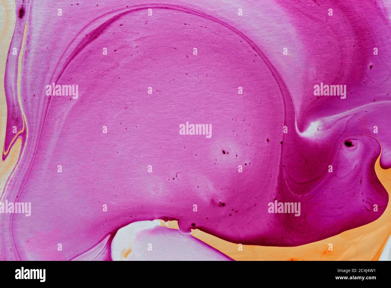 Abstrakter Hintergrund marmoriert Effekt mit Splatter auf wirbelnden Wellen von rosa und gelben Pigment oder Farbe in einem Vollformat Textur und Muster Stockfoto