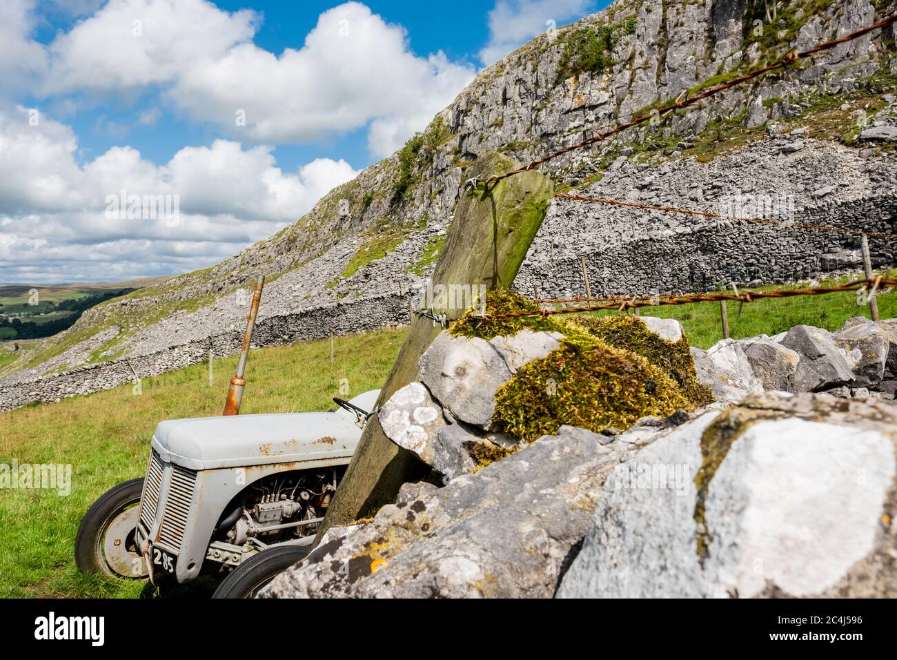 Verlassene, Vintage-Traktor an der Grenze der Felswand hoch in den Dales gesehen. Seit einigen Jahren nicht mehr verwendet, zeigt der Hintergrund eine Schersteinwand. Stockfoto