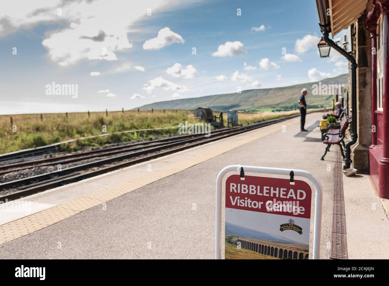 Flacher Fokus eines Besucherzentrums Schild auf dem berühmten Leeds zu Carlisle Bahnhof gesehen. Ein Mitglied der Öffentlichkeit kann in der Ferne gesehen werden. Stockfoto