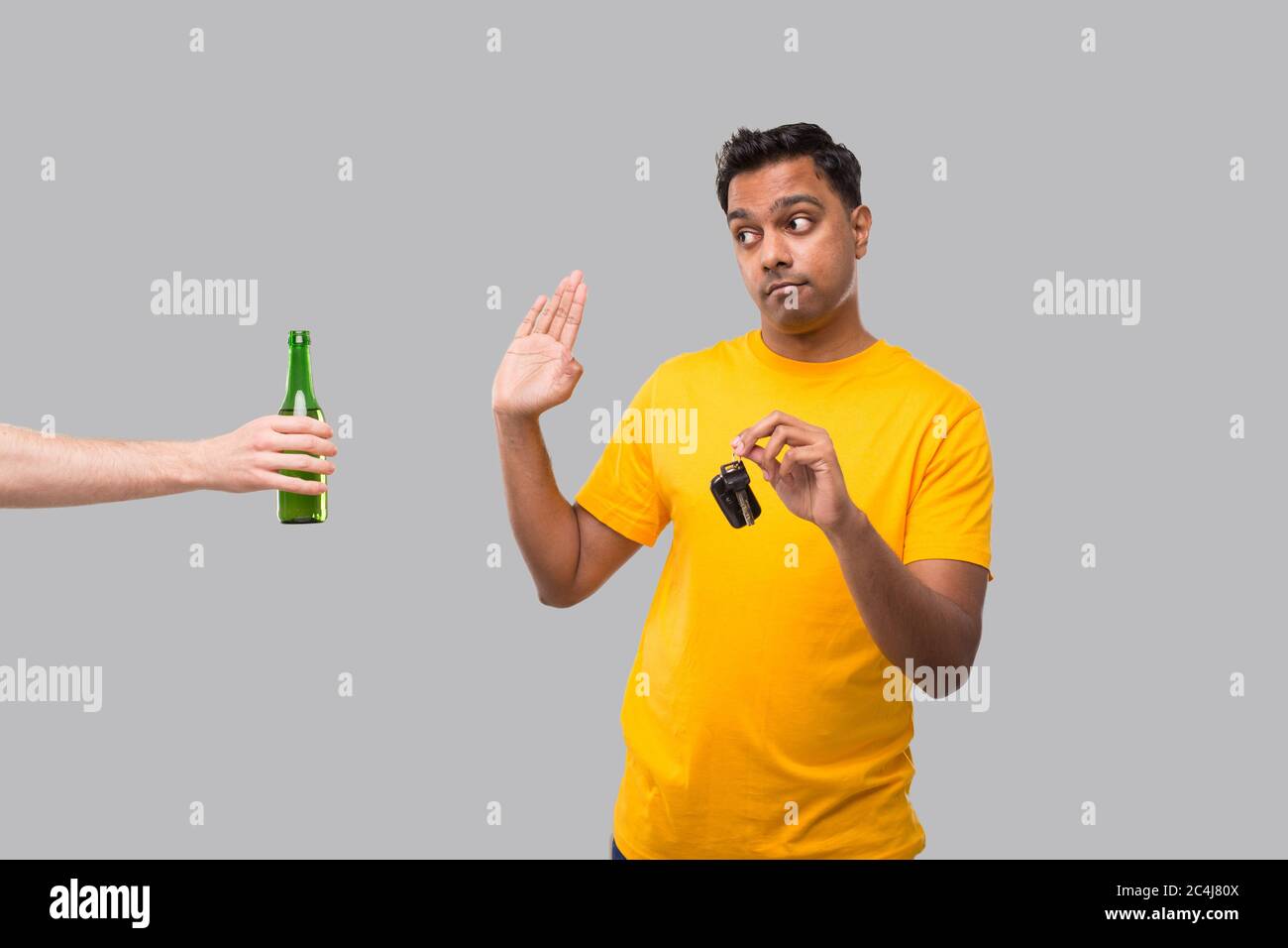 Indischer Mann, der Nein zu Bierflasche sagt, die Autoschlüssel hält. Trinken Sie nicht und fahren Sie Konzept. Der Mensch Trinkt Nicht. Kein Alkohol. Mann, Der Alkohol Ablehnt Stockfoto