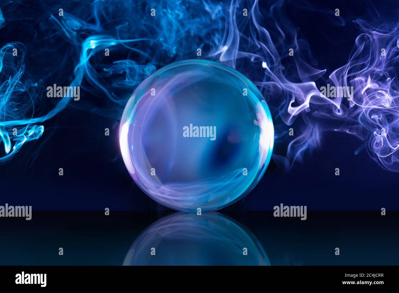 Kristallkugel in einem dunkelblauen rauchigen Hintergrund Stockfoto