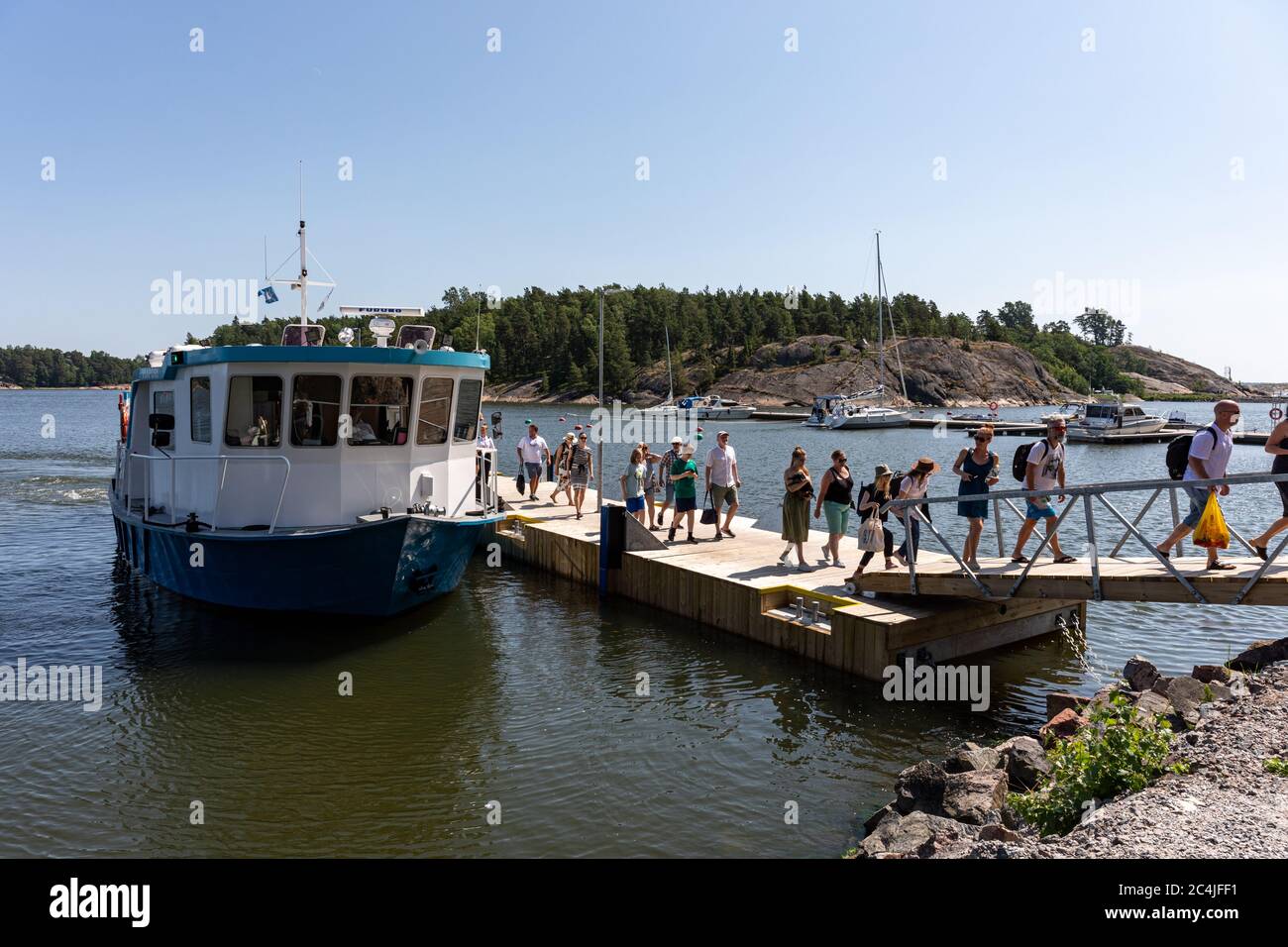 Menschen, die von der Viapori-Fähre zur Insel Vallisaari landen, um an einem sonnigen Tag in Helsinki, Finnland, einen Tagesausflug zu Unternehmen Stockfoto