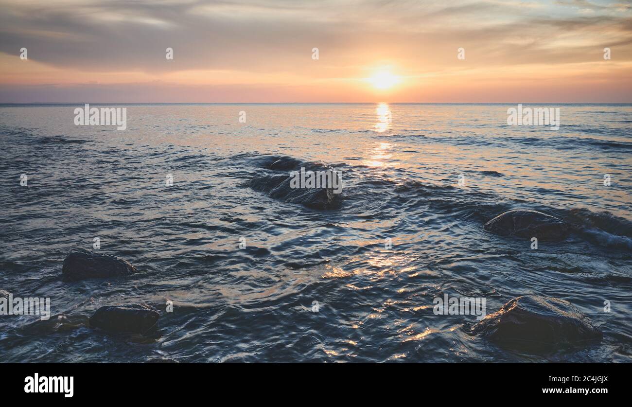 Seeslandschaft mit Felsen im Wasser bei Sonnenuntergang, Miedzyzdroje, Polen. Stockfoto