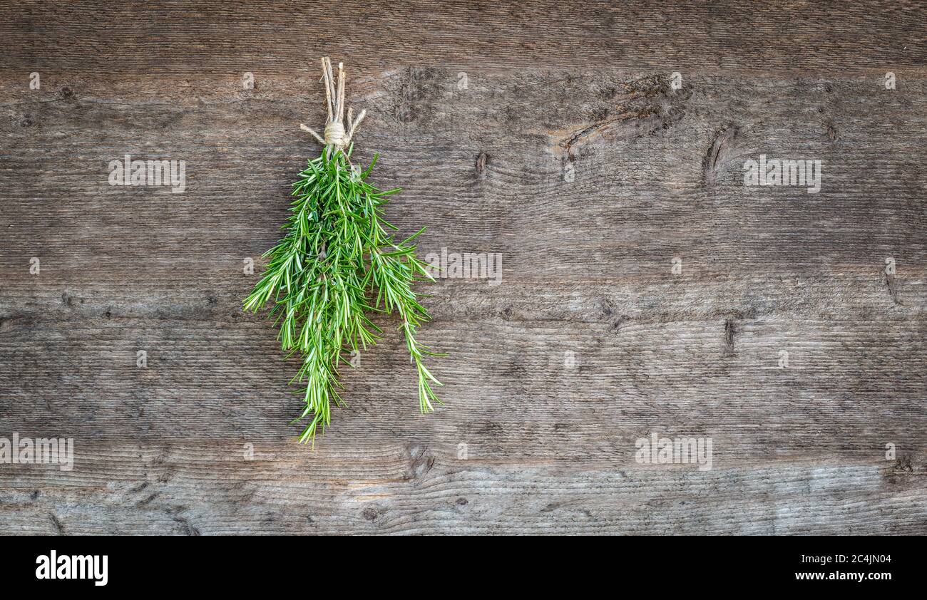 Rosmarin auf Holzhintergrund. Stockfoto