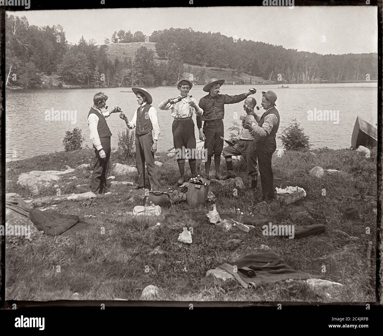 Sechs Männer, die ein Picknick am Seeufer trinken, um 1900. Bild von 4x5 Zoll Glasplatte negativ. Stockfoto