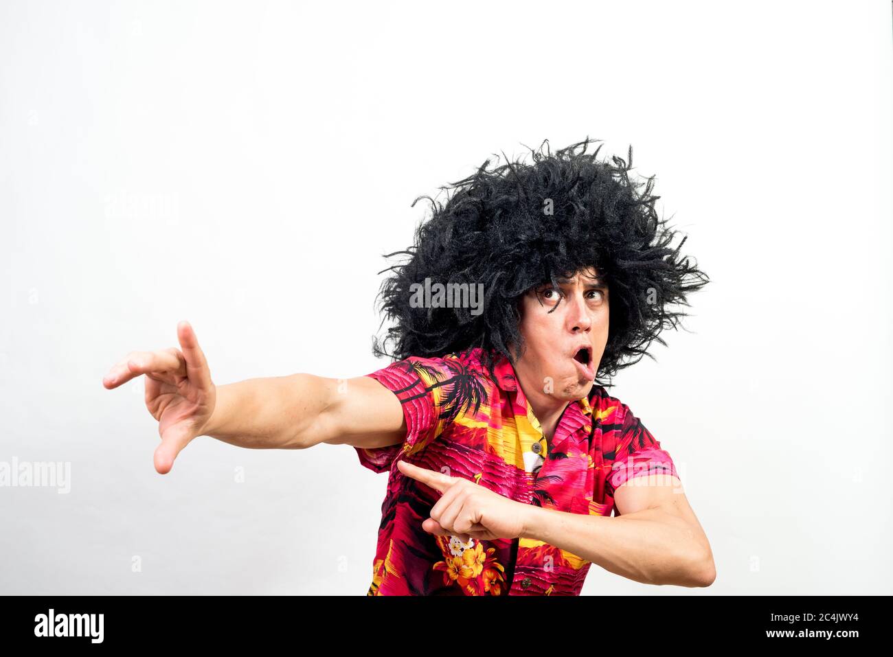 Mann mit Afro Perücke und hawaiihemd, sehr verrückt. Mittlerer Schuss. Weißer Hintergrund. Stockfoto