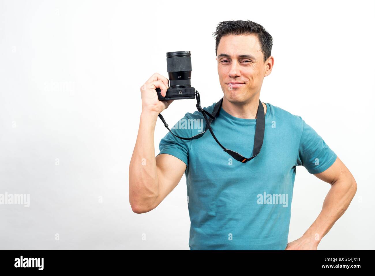Lächelnder Mann zeigt eine Fotokamera. Mittlerer Schuss. Weißer Hintergrund. Stockfoto