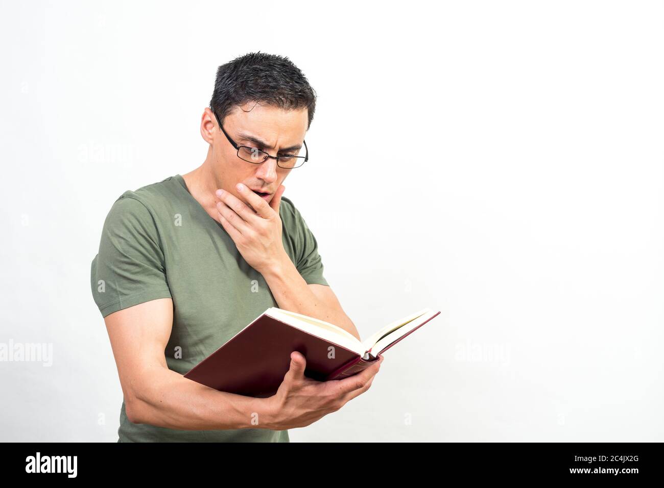 Mann mit Brille, sehr konzentriert auf das Lesen eines Buches. Mittlerer Schuss. Weißer Hintergrund. Stockfoto