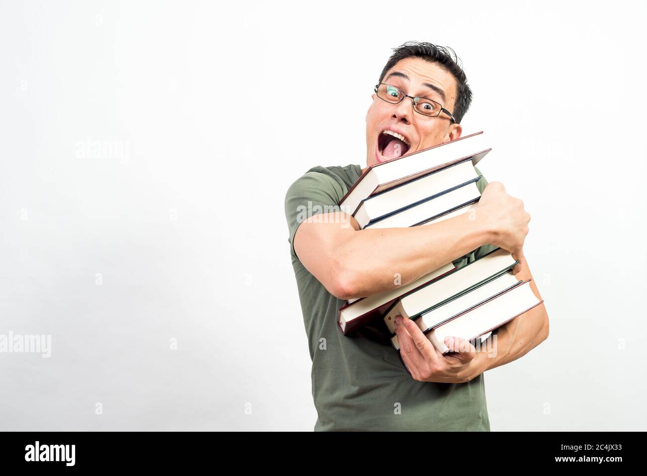 Sehr glücklicher Mann mit Brille, die viele Bücher hält. Mittlerer Schuss. Weißer Hintergrund. Stockfoto