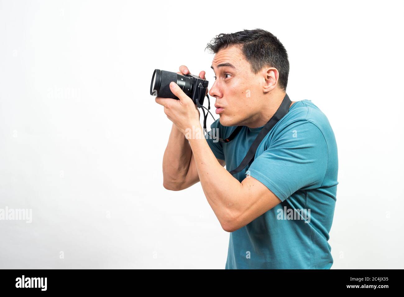 Mann mit Fotokamera, der etwas sehr konzentriertes fotografiert, Seitenansicht. Mittlerer Schuss. Weißer Hintergrund. Stockfoto