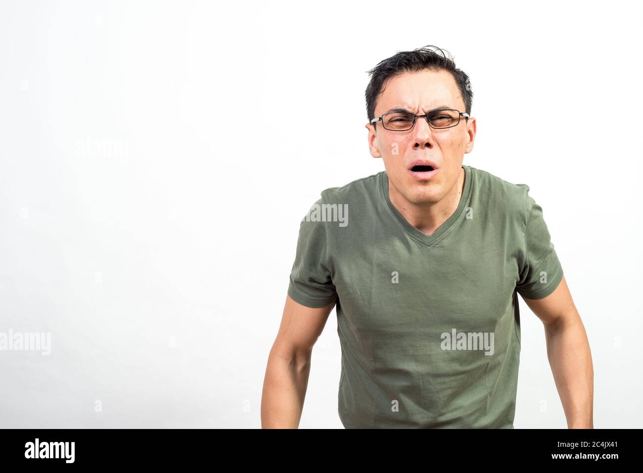 Mann mit Brille, die seine Augen belastet, weil er nicht gut sehen kann. Mittlerer Schuss. Weißer Hintergrund. Stockfoto