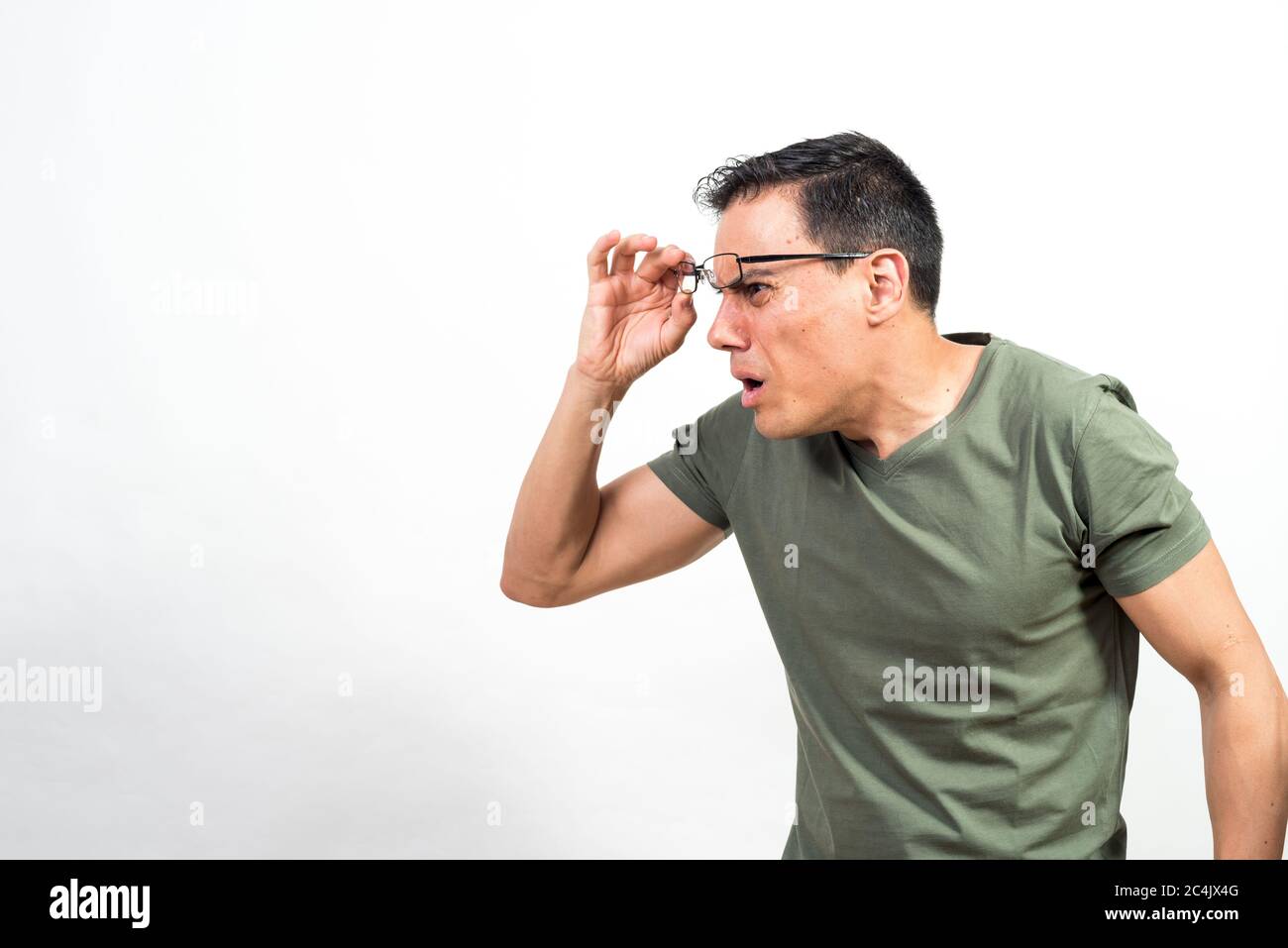 Mann, der seine Brille aufhebt und etwas sehr Überraschendes ansieht. Mittlerer Schuss. Weißer Hintergrund. Stockfoto