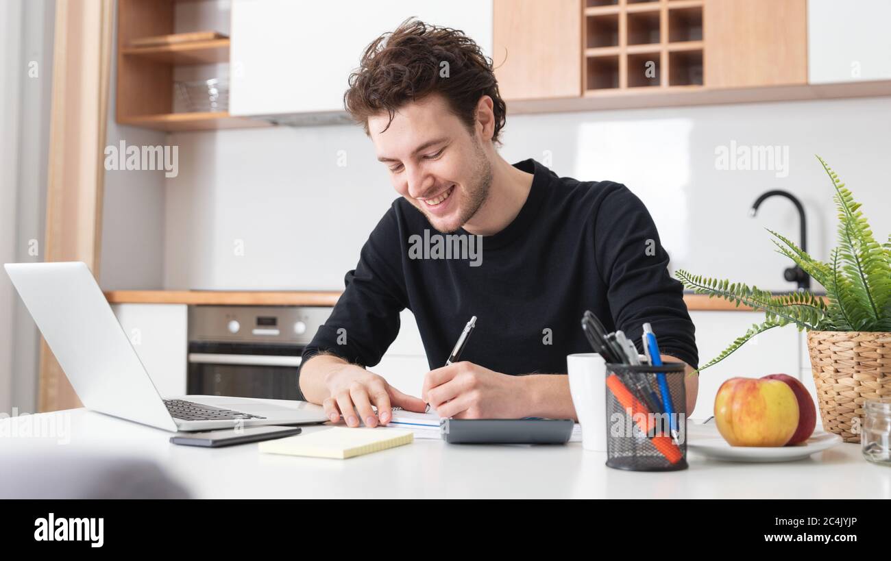 Glücklicher Mann mit Laptop zu Hause. Home Office, Remote-Working-Konzept Stockfoto