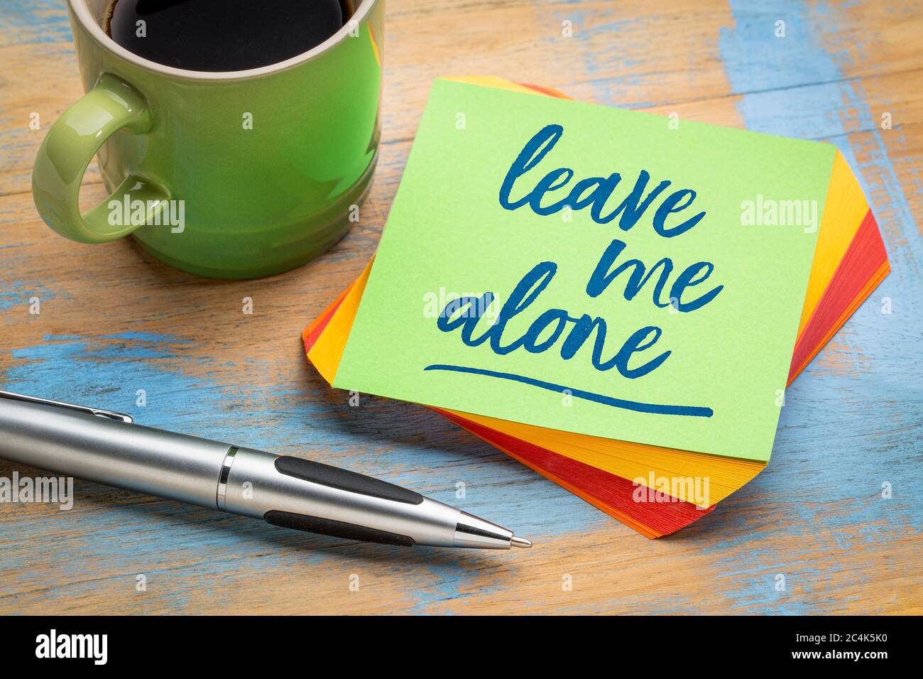 Lassen Sie mich in Ruhe - Handschrift auf einer grünen Haftnotiz mit einem Stift und einer Tasse Kaffee, geschäftliche und persönliche Themen Konzept Stockfoto