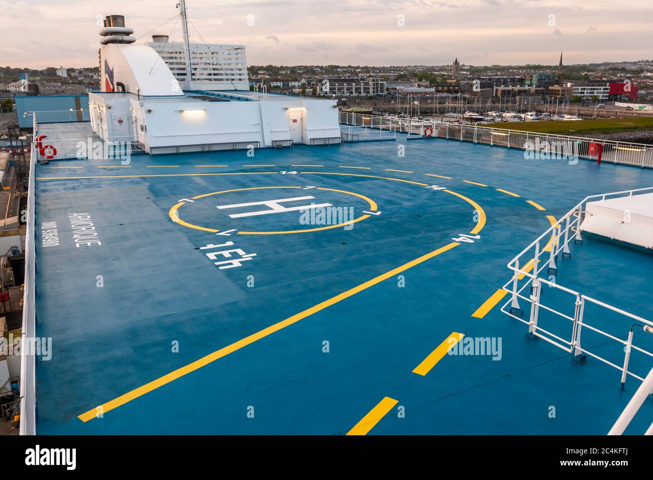 Die Armorique von Brittany Ferries hat einen Hubschrauberlandeplatz mit der Markierung „H“ auf ihrem Oberdeck, mit Blick auf den Hafen von Plymouth, England, und die Stadt Skyline dahinter. Stockfoto