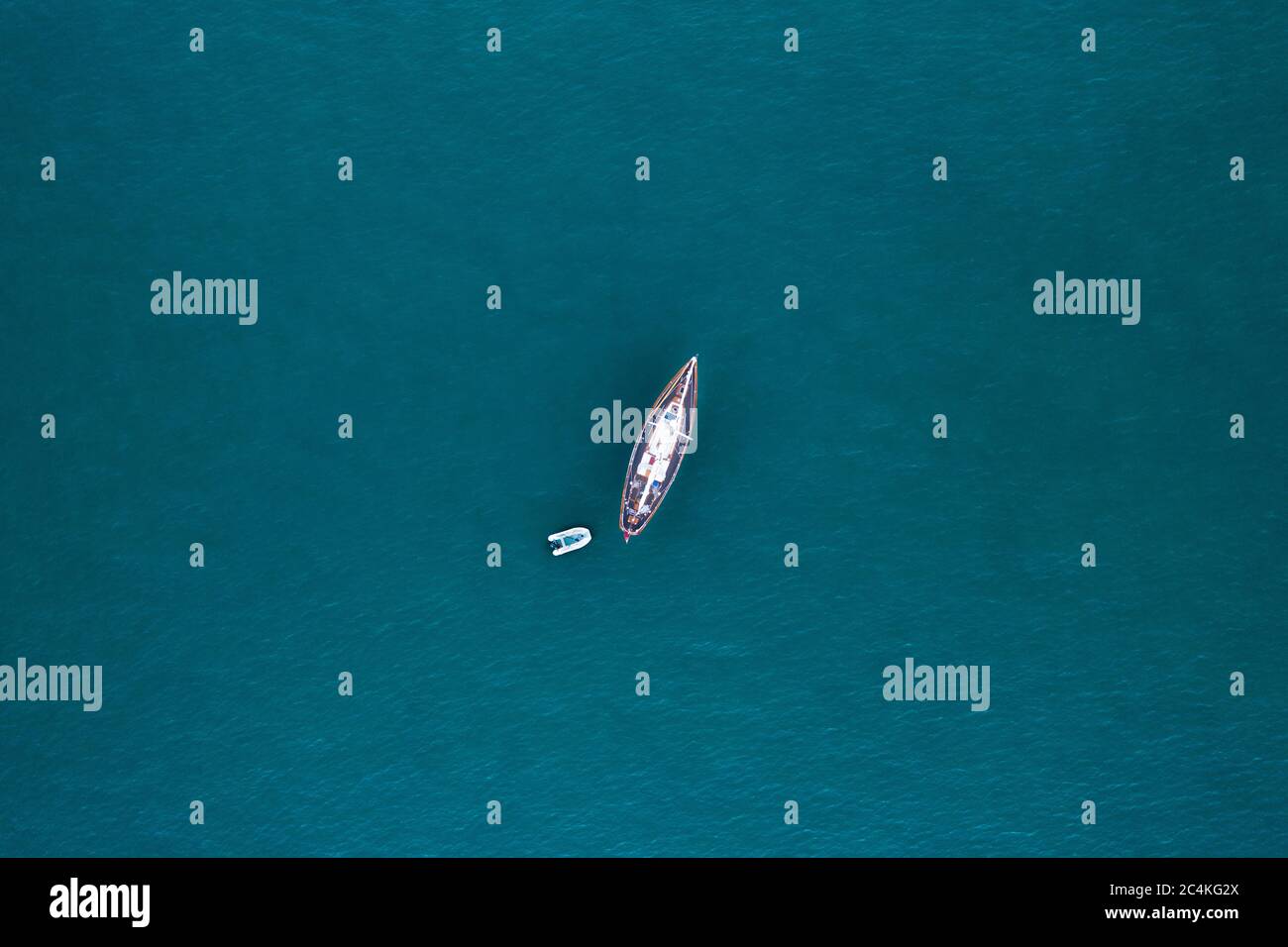 Luftaufnahme aus der Vogelperspektive mit Drohne eines Bootes in der karibik tropischen mit türkisfarbenem Meer angedockt Stockfoto