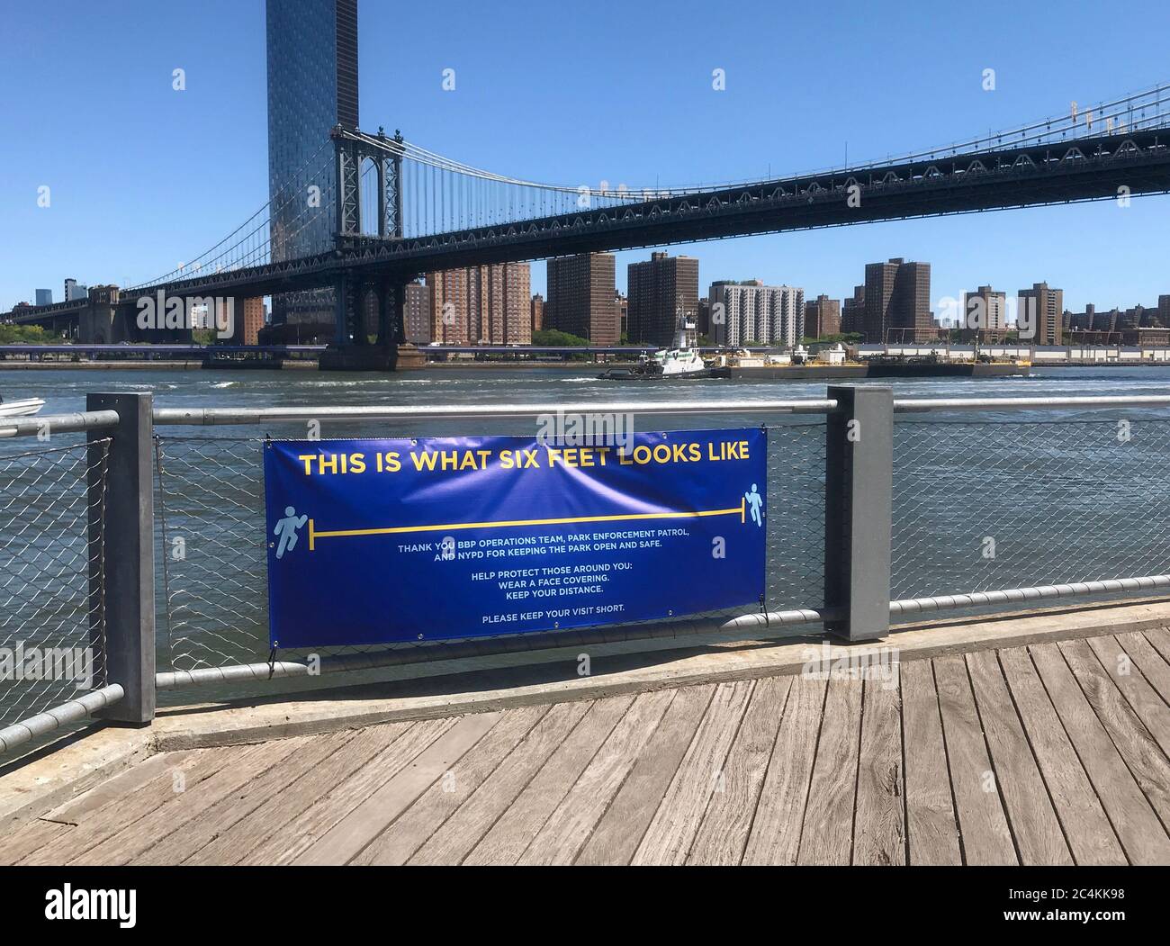 Soziale Distanzierungszeichen im Brooklyn Bridge Park, das die Menschen daran erinnert, sechs Meter auseinander zu halten, um die Ausbreitung des Coronavirus / COVID-19 zu verhindern Stockfoto