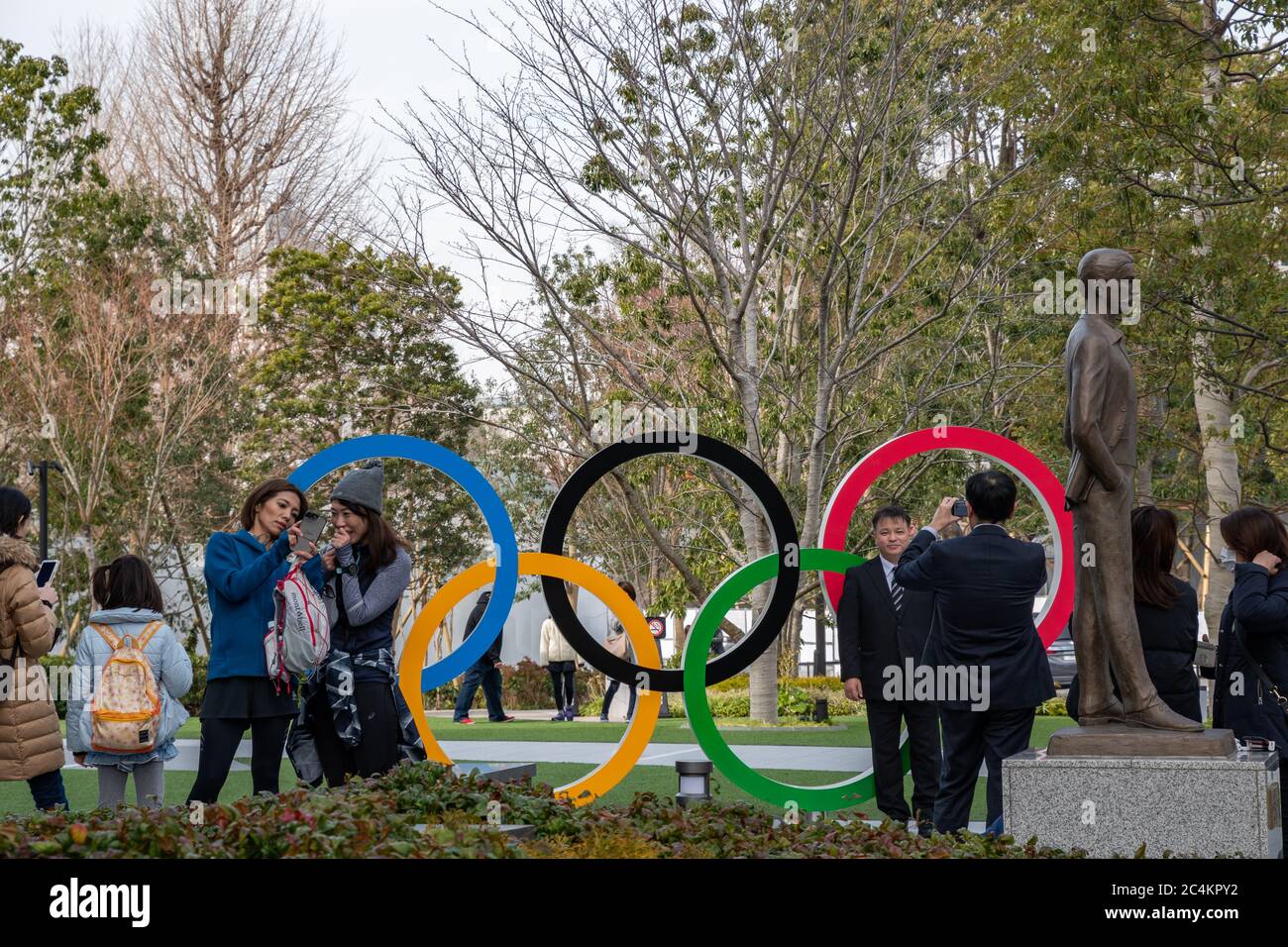 Menschen, die mit dem fünf-Ring-Symbol vor dem Olympischen Museum und dem neuen Nationalstadion für Tokio Olympic 2020 fotografieren. Stockfoto