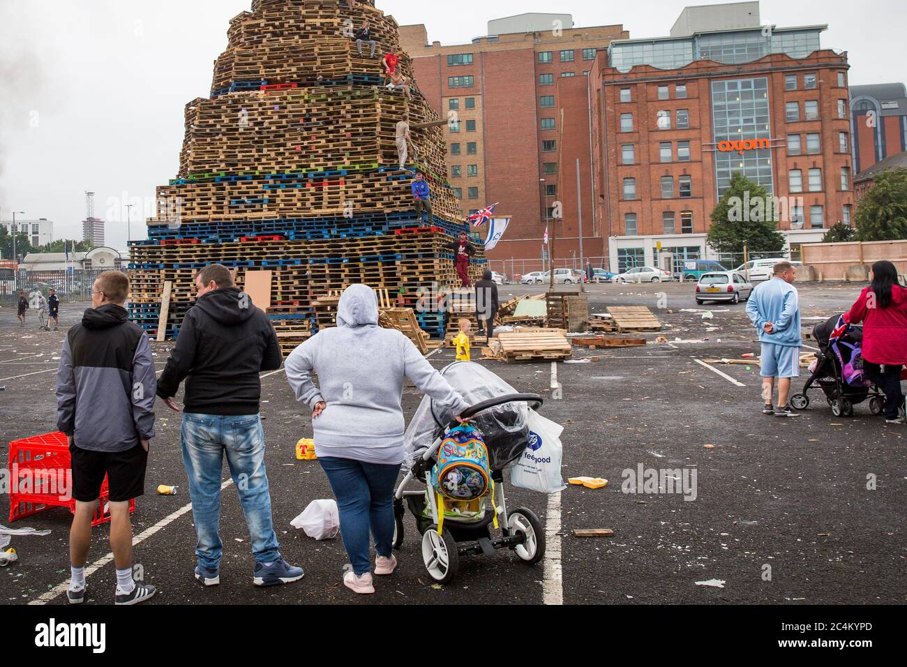 Anwohner beobachten, wie ein Lagerfeuer in Sandy Row, Belfast, Nordirland, gebaut wird. Stockfoto