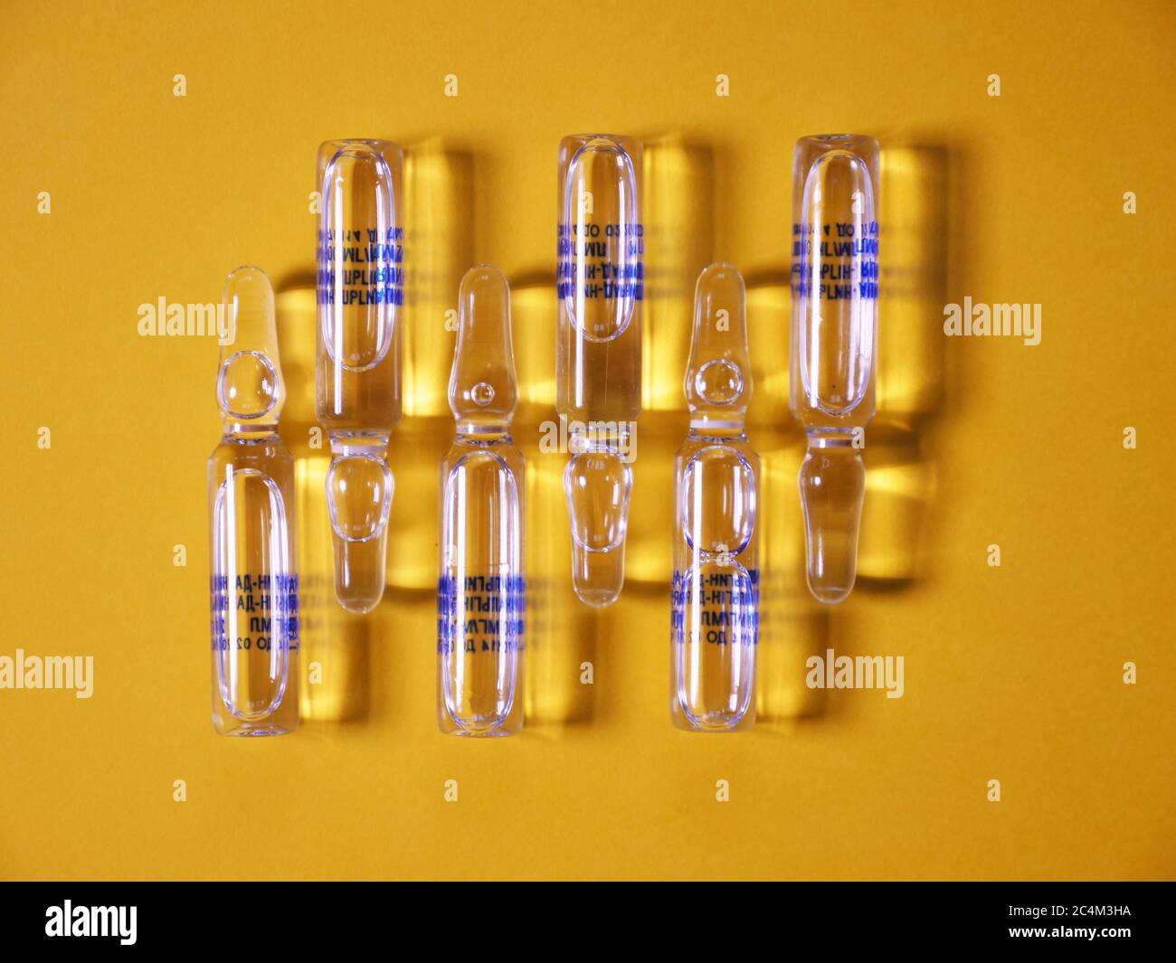 Ampulle auf gelbem Hintergrund zur Behandlung von Coronavirus Covid19 Stockfoto
