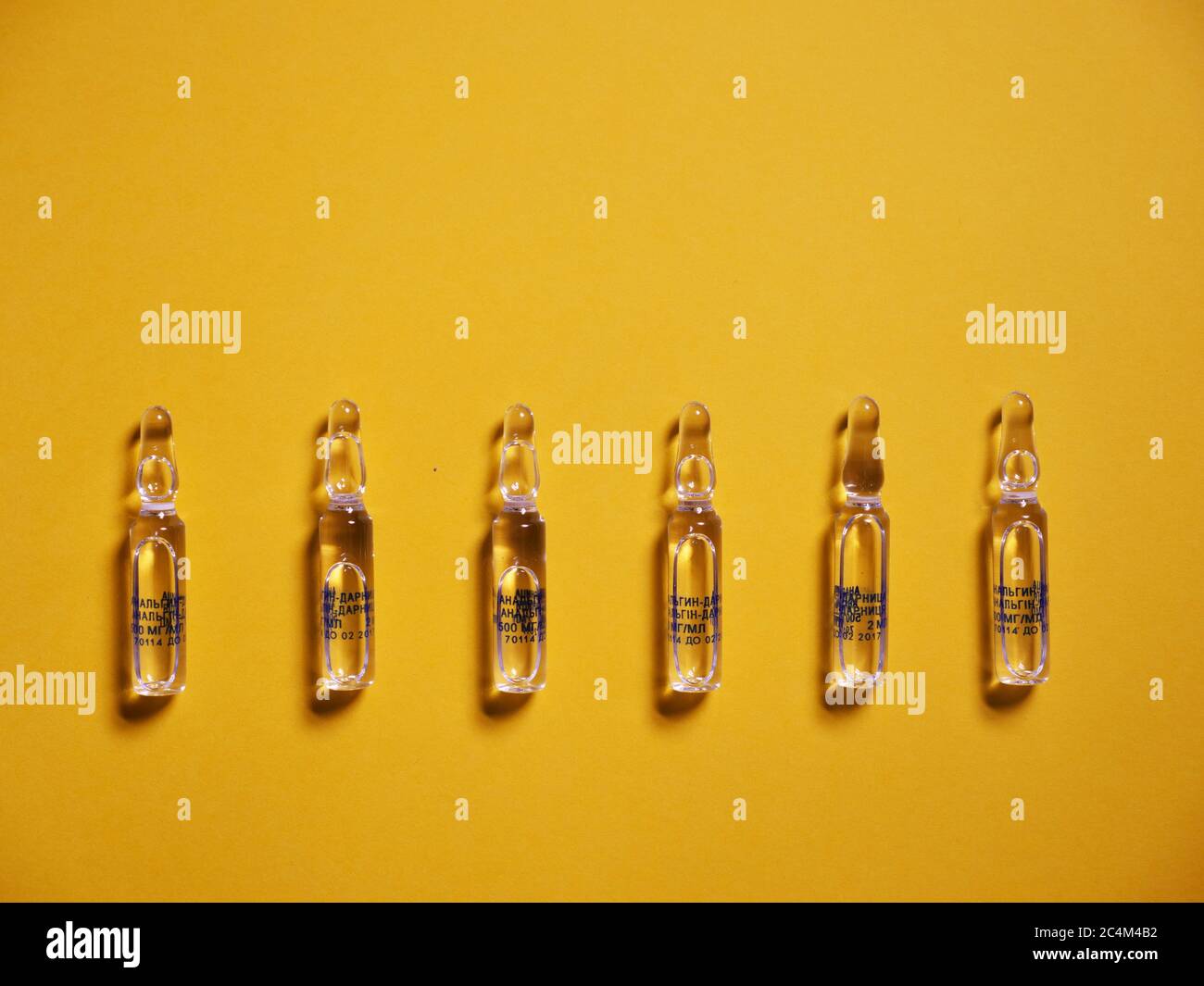 Ampulle auf gelbem Hintergrund zur Behandlung von Coronavirus Covid19 Stockfoto