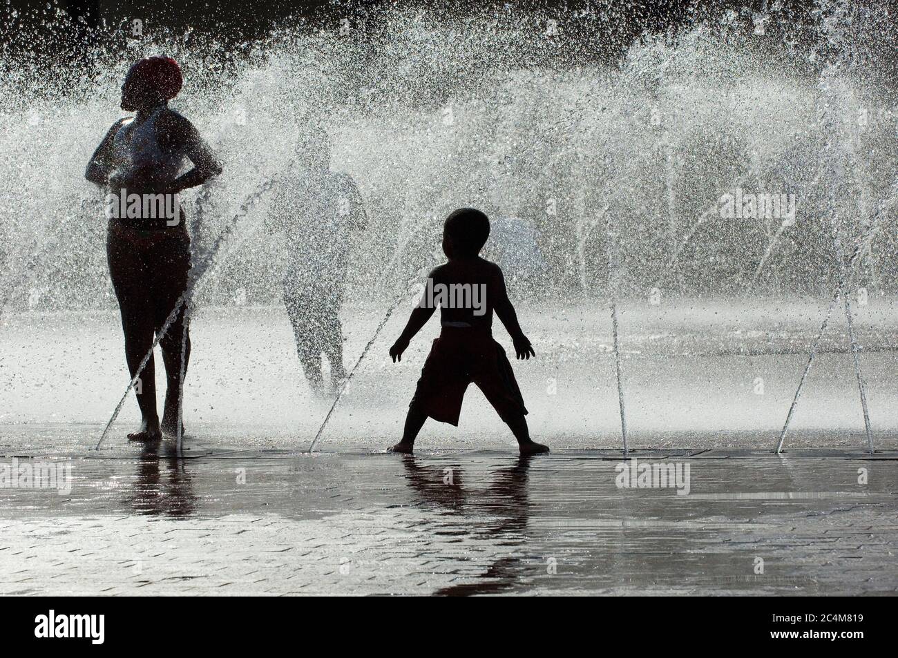 Kinder spielen in der Sommerhitze im Springbrunnen Stockfoto