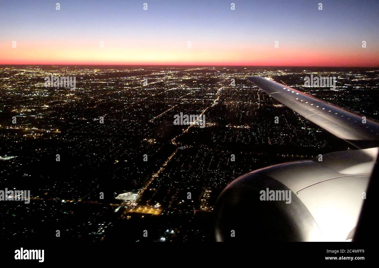 Flugzeug über eine Stadt mit rotem Horizont Stockfoto