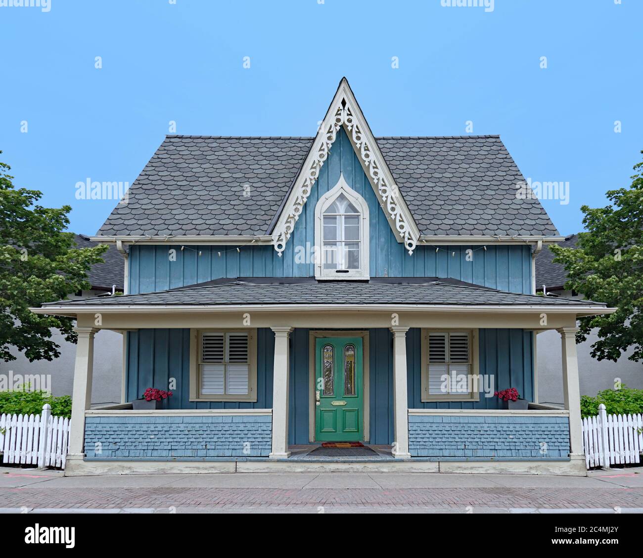 Altmodisches kleines Haus im amerikanischen gotischen Stil mit Giebel und voller Veranda Stockfoto