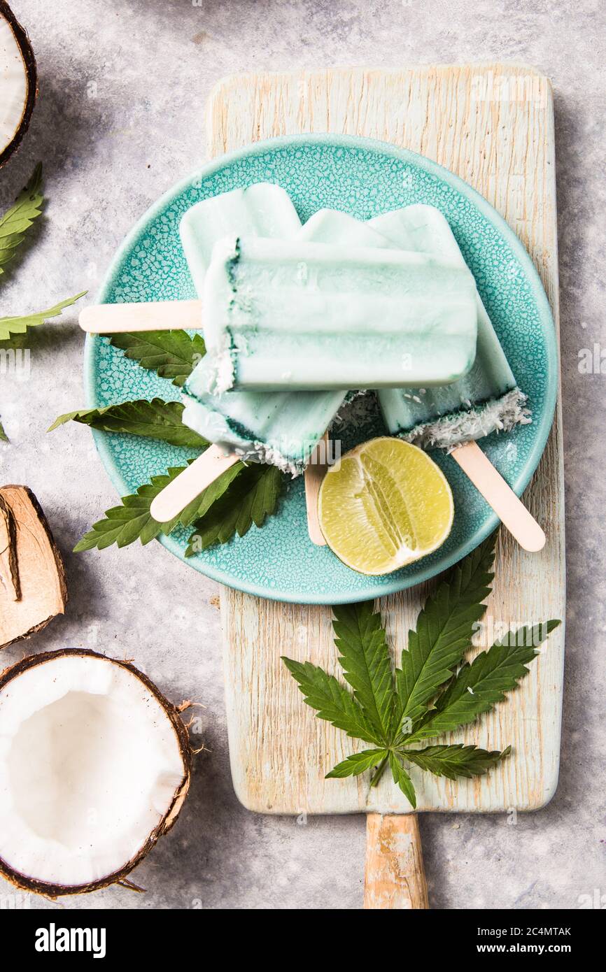 Eis-Eis-Eisdielen mit Kokosnussscheiben, Cannabis auf Betongrund. Stockfoto